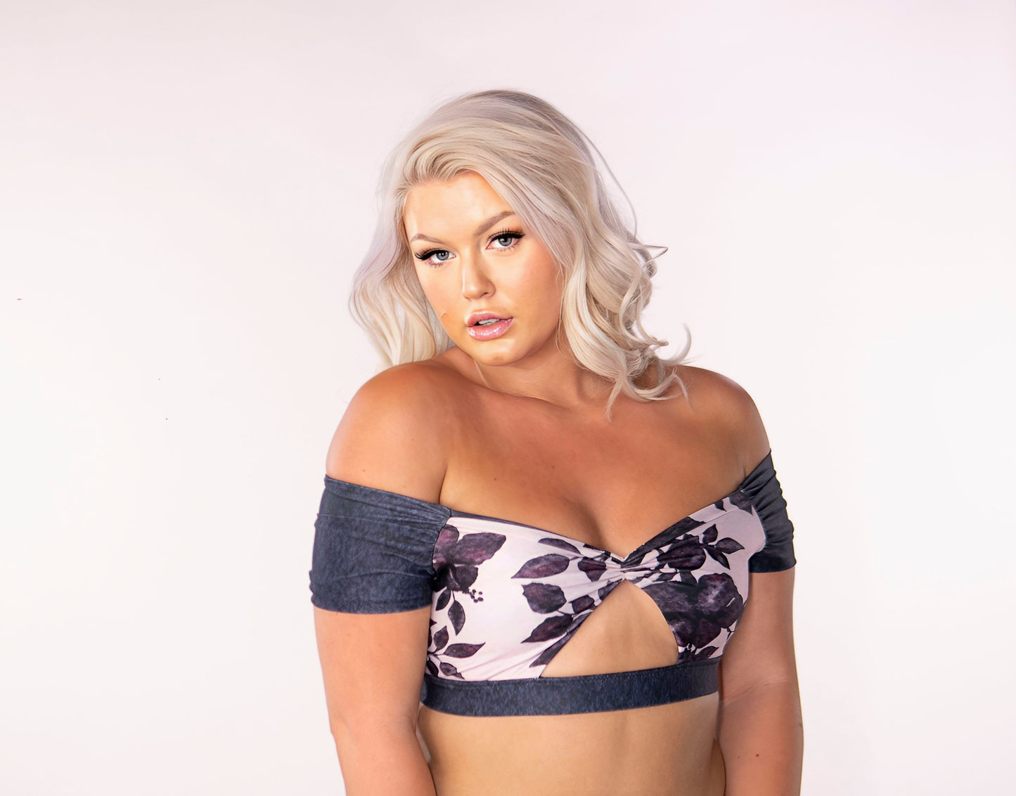 A reversible off the shoulder bikini top, solid navy blue wash on one side and on the other, a girlie pink floral pattern featuring blue hibiscus watercolour print. The front features a traingular cut away under the bust and a gathered center detail. The sleeves and broad elastic chest band neatly frame the design in solid navy blue.